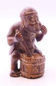 A netsuke formed as a man and a drum. 5.5 cm high.