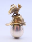 A silver helmet and egg pendant bearing Russian marks. 4 cm high.