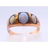 A 9 ct gold three-stone opal ring. Ring size L/M.