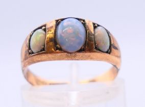 A 9 ct gold three-stone opal ring. Ring size L/M.