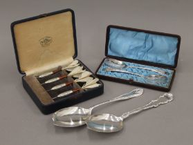 A cased set of silver-plated darts,