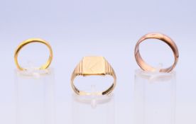 A 22 ct gold wedding band 3.8 grammes, a 9 ct gold wedding band and a 9 ct gold signet ring 8.