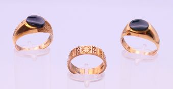 Two 9 ct gold signet rings and a 9 ct gold wedding band. 11.1 grammes total weight.