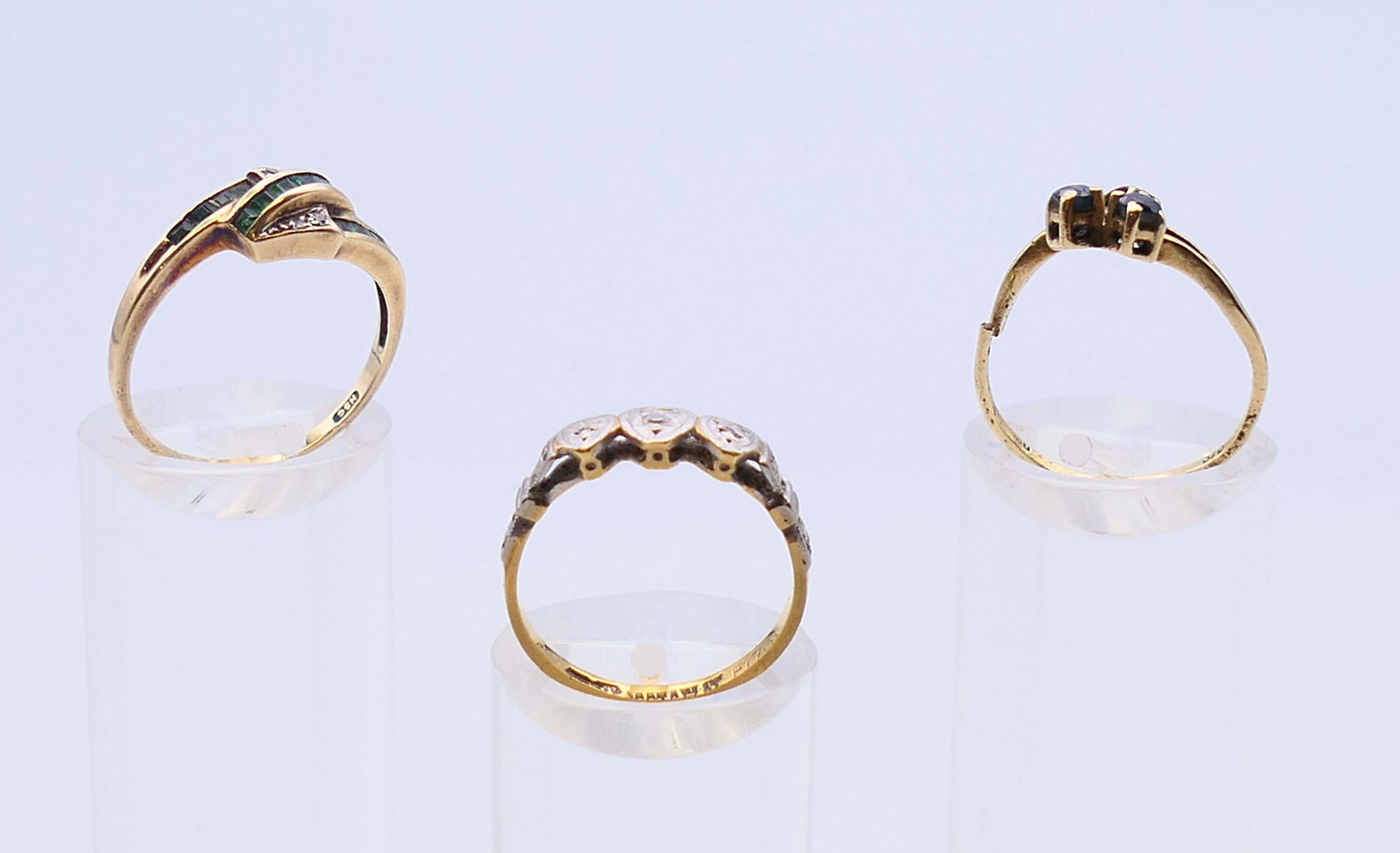 Three various gold, diamond, sapphire and emerald set rings. 4.5 grammes total weight.