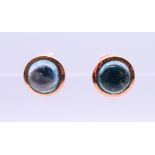 A pair of 9 ct rose gold earrings set with star cut/cabochon topaz gemstones. 0.5 cm diameter.