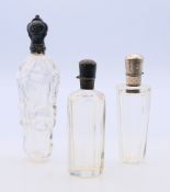 Three silver topped scent bottles. Largest 12.5 cm high.