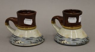 A pair of stoneware beakers decorated with yachting scenes. 9 cm high.