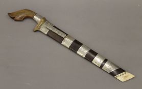 An antique Eastern unmarked white metal mounted short sword,