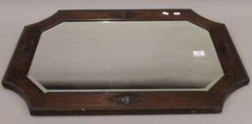 An early 20th century oak-framed bevelled mirror. 80 cm wide.