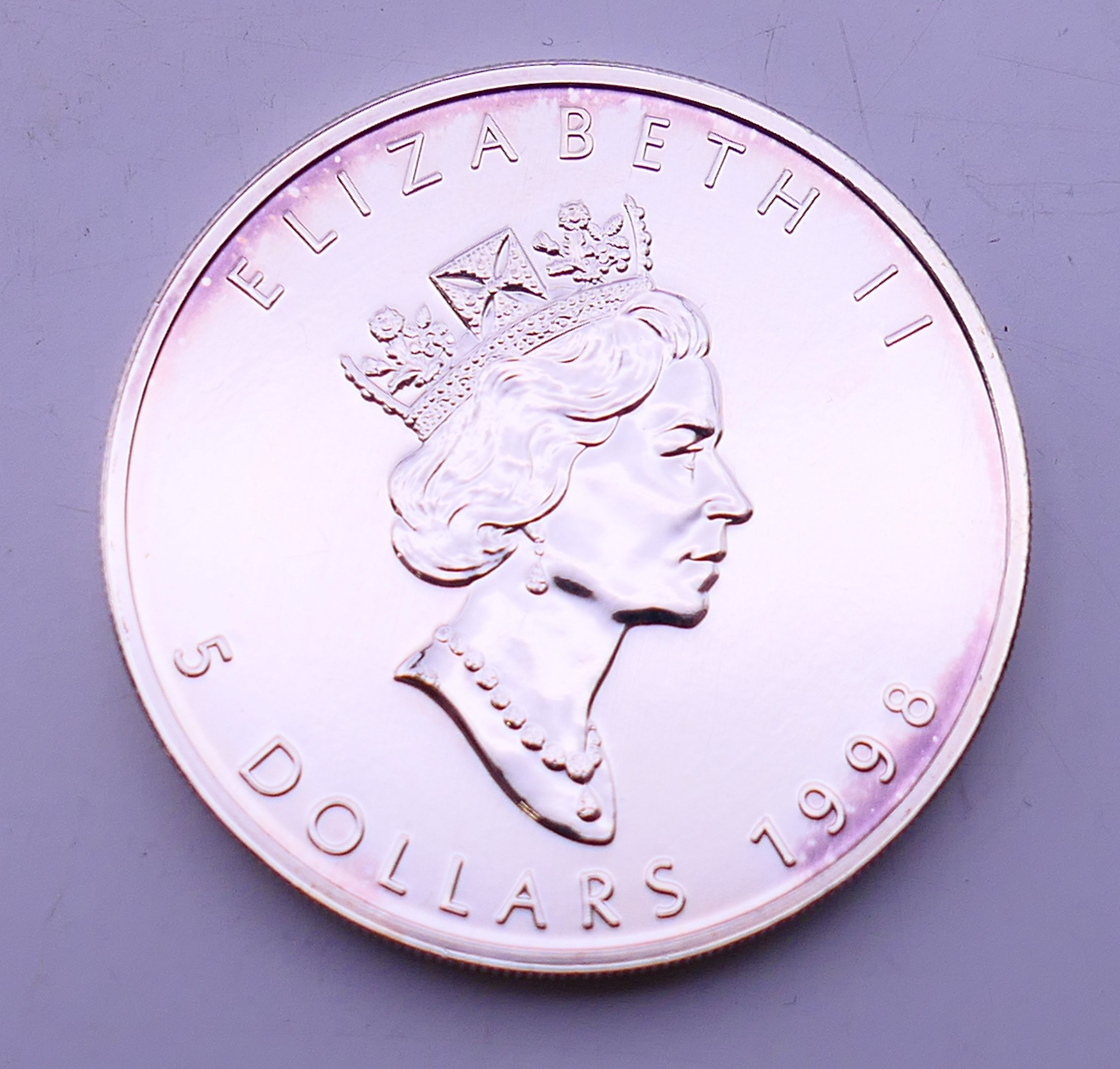 A 1998 Canadian fine silver one ounce 5 dollar maple leaf coin.