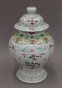 A 19th century Chinese porcelain polychrome decorated baluster vase and cover with panels of