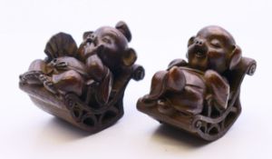 A pair of bronzes of seated pigs. 4.5 cm high.