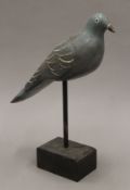 A vintage painted carved wooden pigeon decoy on stand. 35 cm long.
