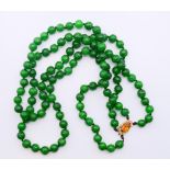 A double string of jade beads with a 14 ct gold and citrine clasp. 64 cm long.