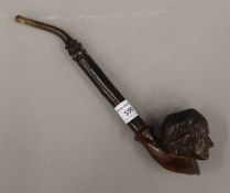 A carved wooden pipe formed as the head of an old man. 25 cm long.