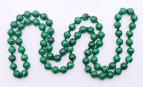A string of malachite beads. 92 cm long.