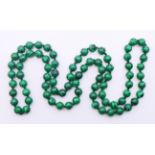 A string of malachite beads. 92 cm long.