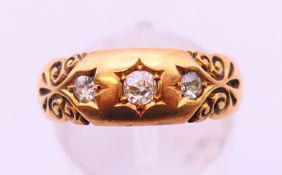 An 18 ct gold three stone gypsy set ring. Ring size O.