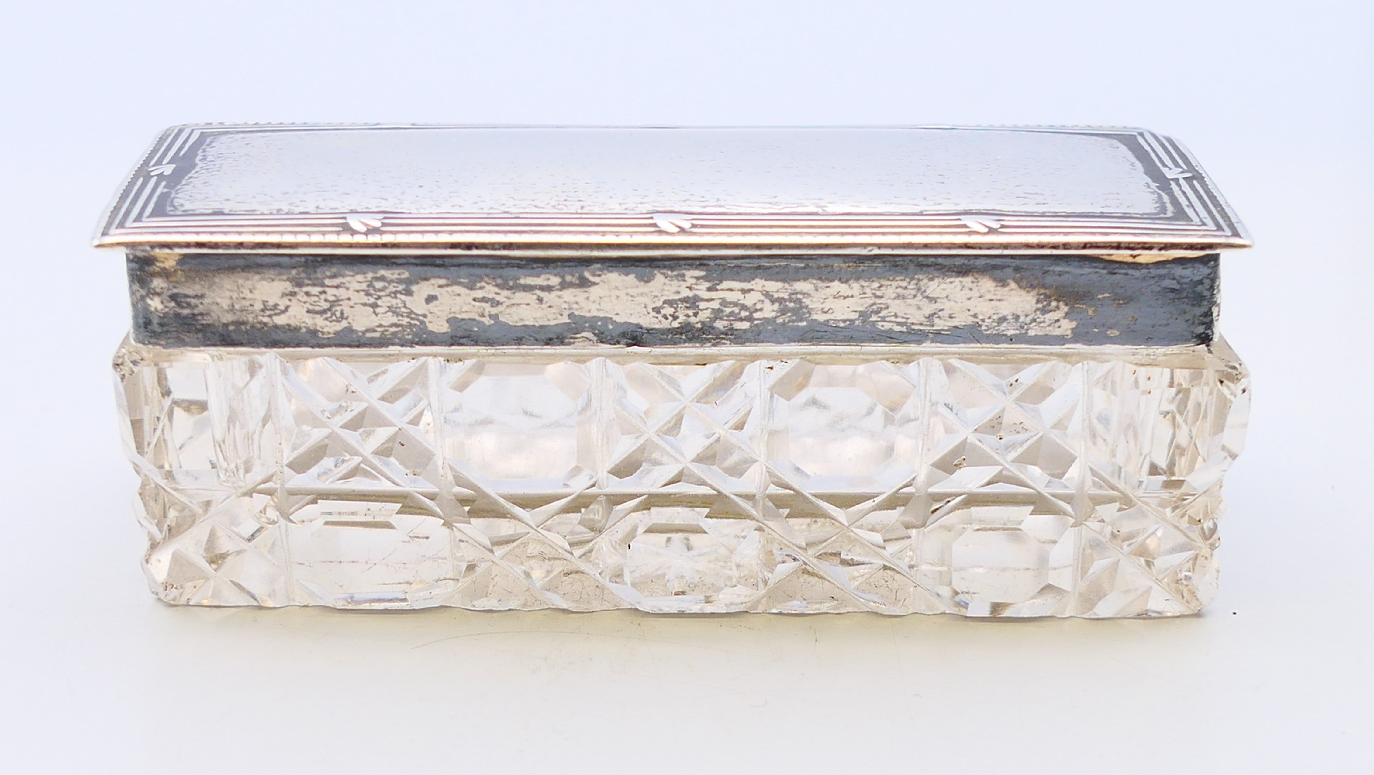 A cut-glass trinket box with silver lid, hallmarked Birmingham 1906. 9 cm x 3 cm.