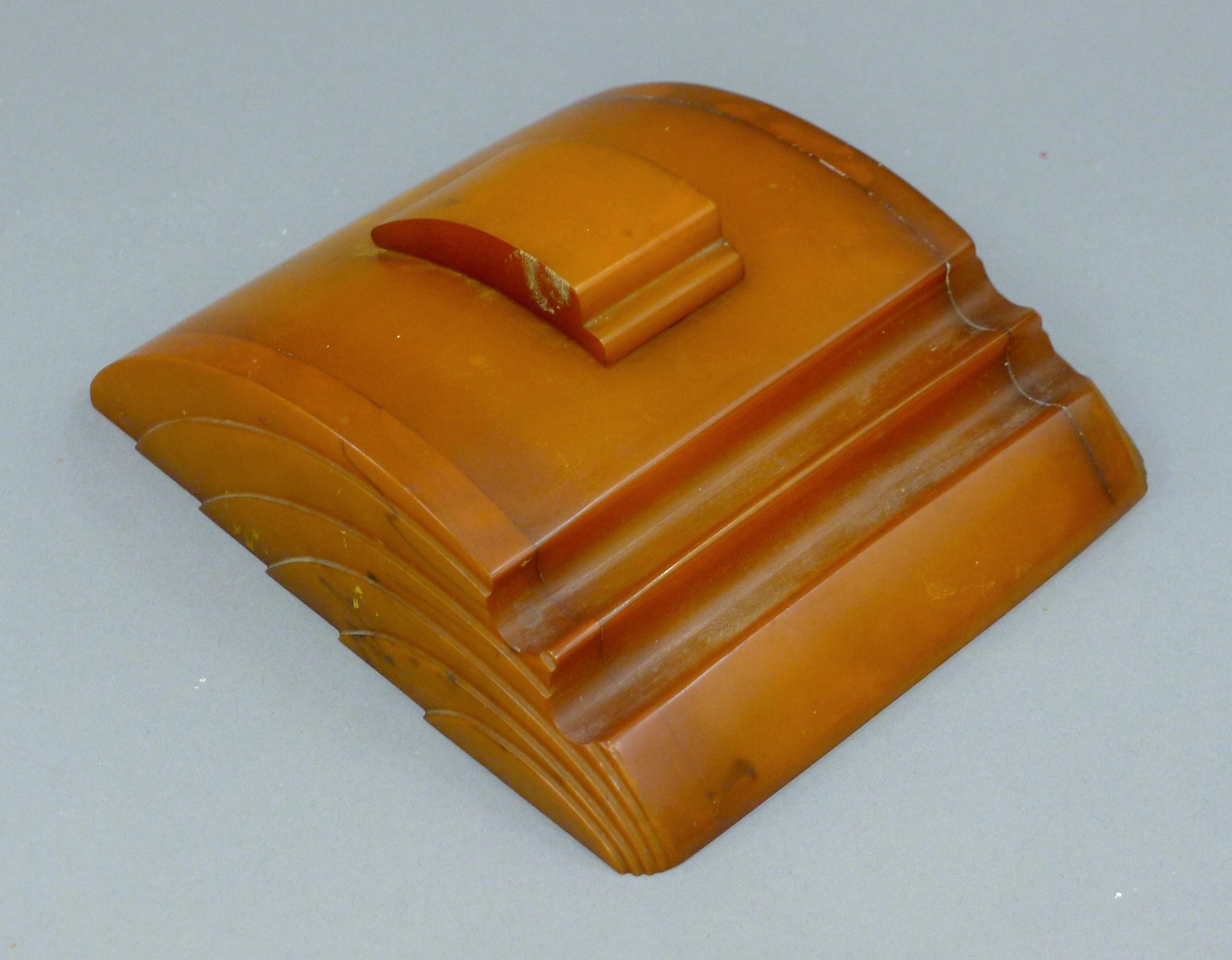 An Art Deco amber bakelite inkstand. 17.5 x 15.5 cm.