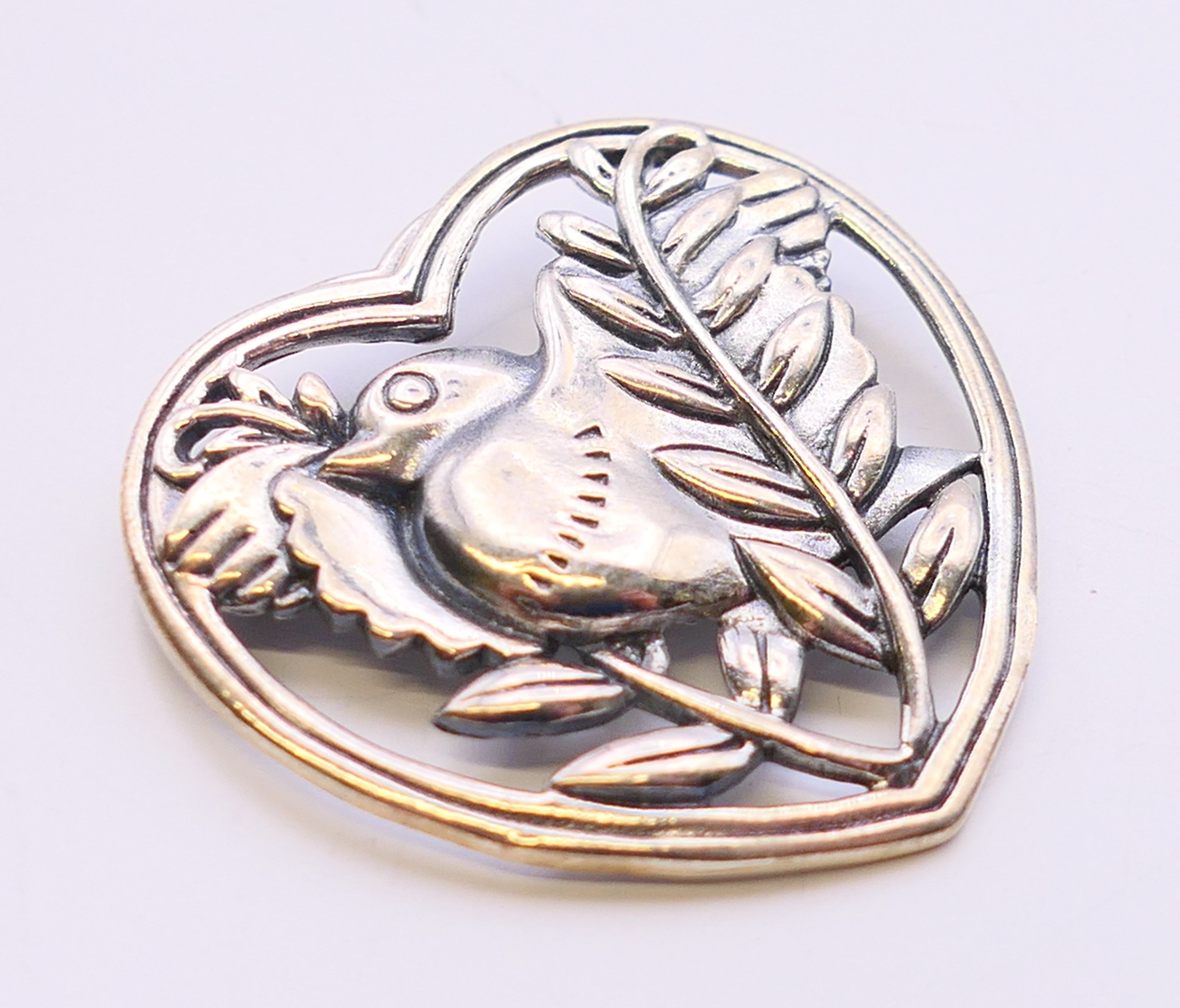 A silver brooch in the form of a bird within a heart. 3.25 cm high. - Image 2 of 4