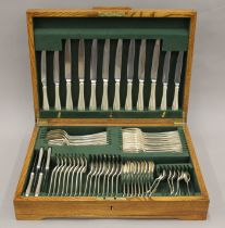 An oaked-cased silver-plated cutlery canteen. 49 cm wide.