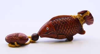 An inro formed as fish with a smaller fish netsuke. Largest fish 12 cm long.