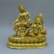 A gilt bronze figure of two deities. 29 cm high.