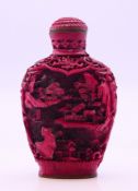 A cinnabar snuff bottle and stopper. 7 cm high.