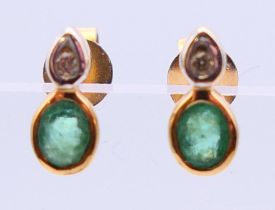 A pair of 9 ct gold earrings set with diamonds and emeralds. 0.75 cm high.