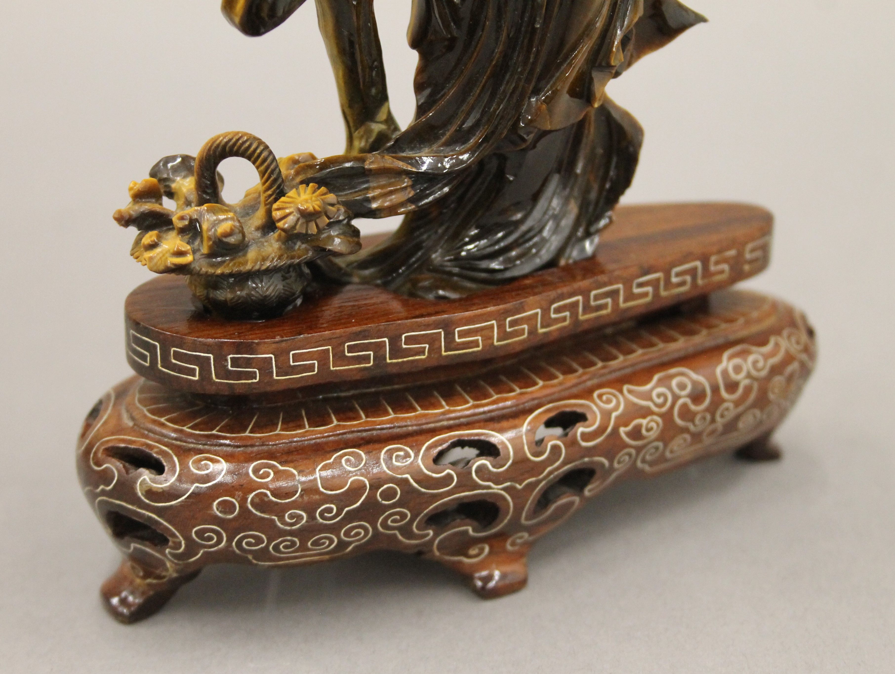 A Chinese tiger's eye hardstone carving of a maiden on a carved wood base. 18.5 cm high. - Image 5 of 5