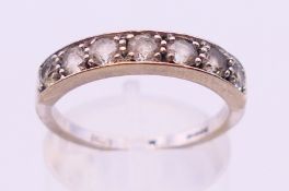 An 18 ct white gold ring set with seven stones. Ring size O.