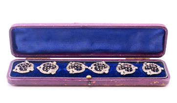 A cased set of six unmarked white metal buttons set with stones, boxed. Each 2.75 cm diameter.