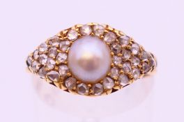 An unmarked gold diamond and pearl ring. Ring size O.
