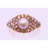 An unmarked gold diamond and pearl ring. Ring size O.