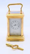 A gilt bronze miniature carriage clock, with key. 7.5 cm high excluding handle.