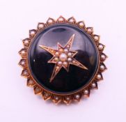 A Victorian seed pearl set mourning brooch. 3.5 cm diameter.