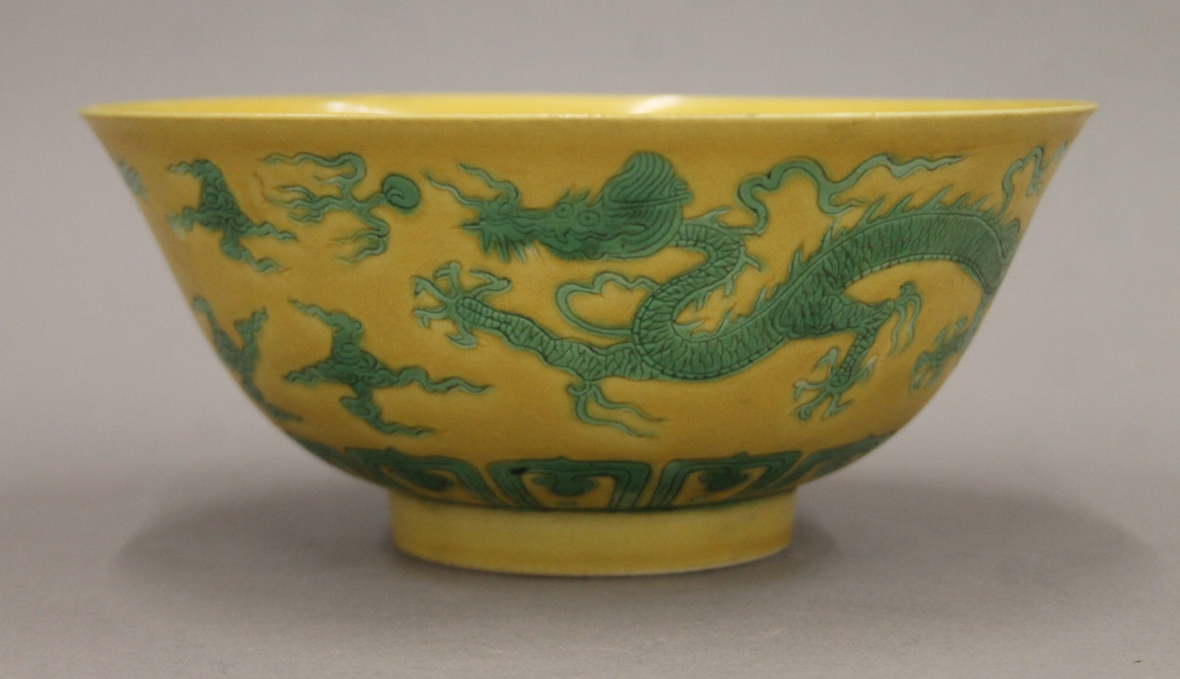 A Chinese yellow ground porcelain bowl decorated with five-clawed dragons chasing a flaming pearl. - Image 2 of 4