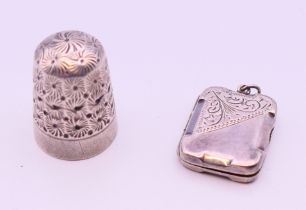 A silver double photo locket and a silver thimble. Thimble 2.5 cm high, locket 2.25 x 1.75 cm.