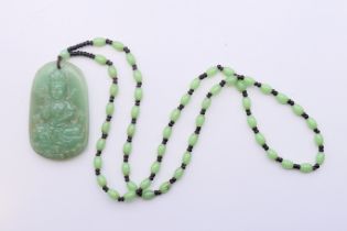 A Chinese jade pendant on a green and black bead necklace. Pendant 6 cm high, necklace 62 cm long.