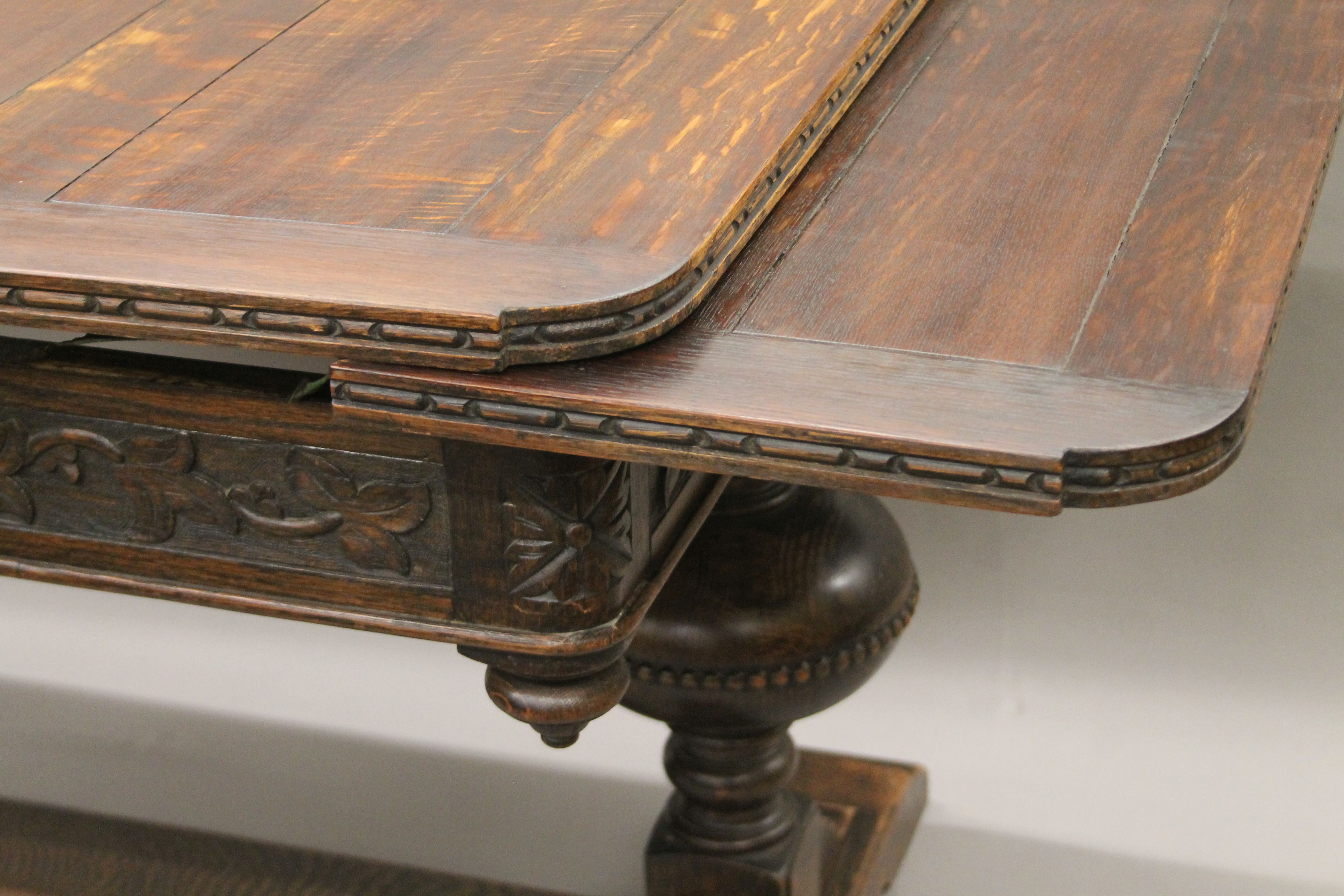 An early 20th century carved oak drawer leaf dining table. 193 cm long extended x 99 cm wide. - Image 2 of 6