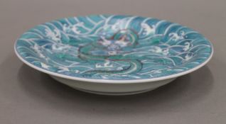 A Chinese porcelain dish decorated with a five-clawed dragon. 21.5 cm diameter.