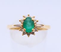 An 18 ct gold, diamond and emerald ring. Ring size R/S.