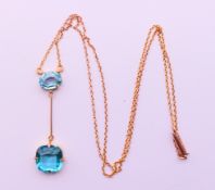 A 9 ct gold pendant and chain set with two cut blue topaz. Pendant 4 cm high, chain 42 cm long. 3.