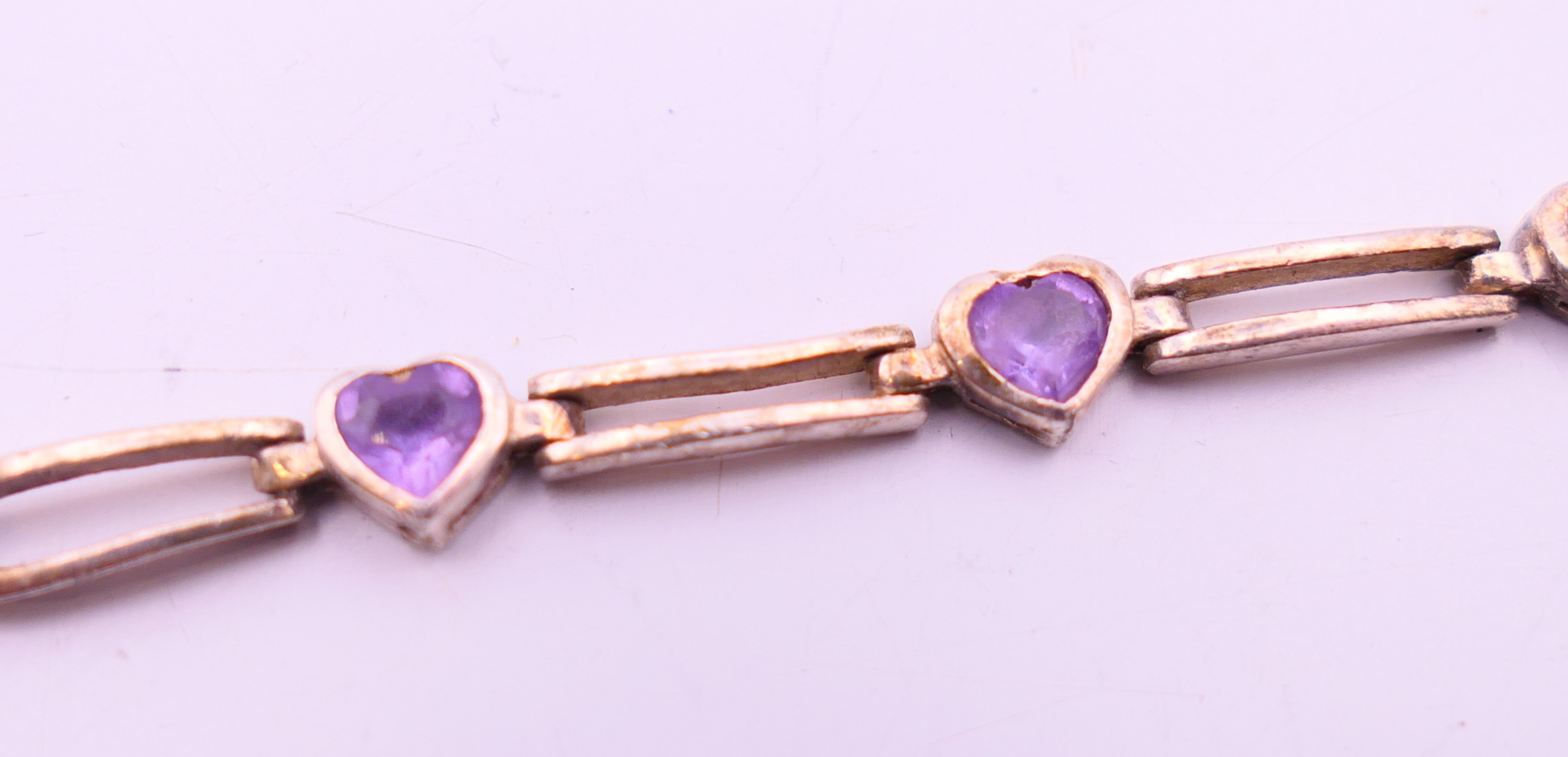 A silver bracelet set with heart shaped amethysts. 17 cm long. - Image 3 of 4