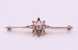 An antique bar brooch with diamond set star design, the central diamond approximately 0.5 carat.