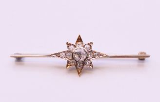 An antique bar brooch with diamond set star design, the central diamond approximately 0.5 carat.