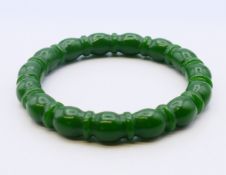 A jade ribbed nephrite bangle. 6 cm internal diameter.