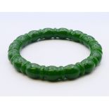 A jade ribbed nephrite bangle. 6 cm internal diameter.