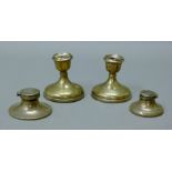 Two silver inkwells and a pair of damaged silver candlesticks. The latter 8.5 cm high.